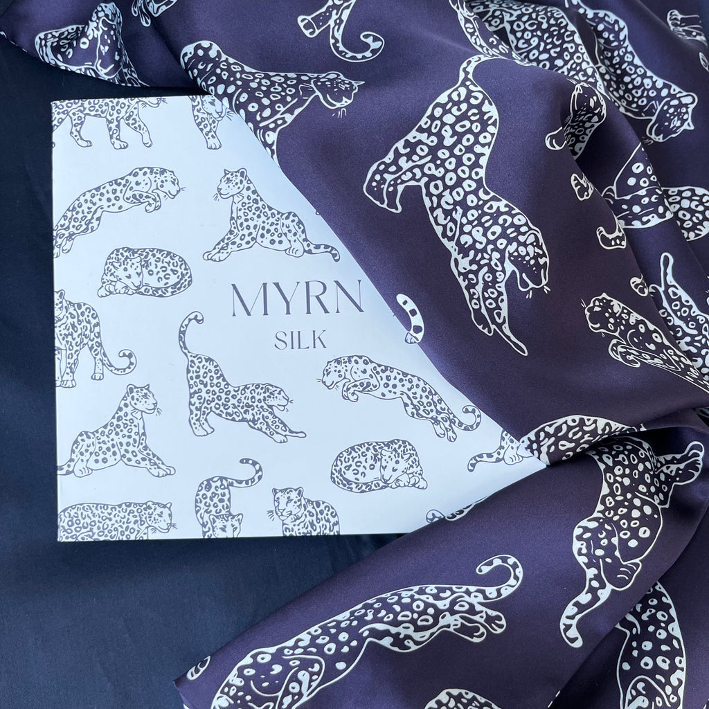 MYRN Silk blue branded box with a dark blue leopard print silk pillowcase draped over it