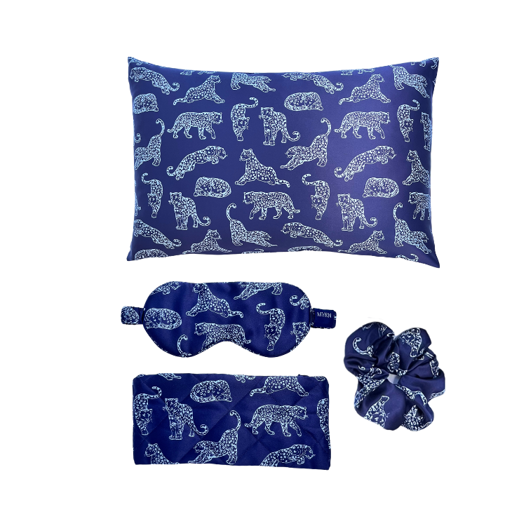 MYRN Silk dark blue leopard printed silk pillowcase, scrunchie and eye mask and silk travel case on a white background