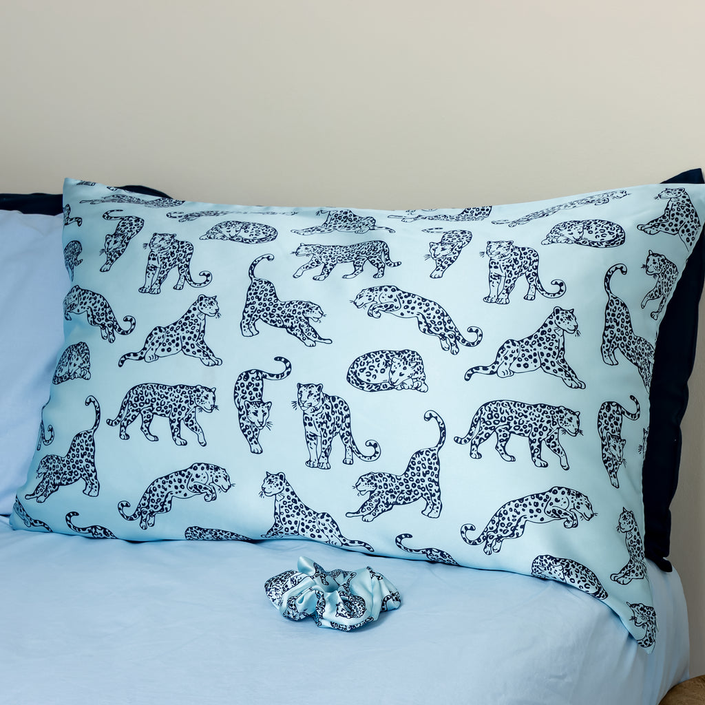 MYRN light blue silk pillowcase on a blue bedding set with a matching silk scrunchie.
