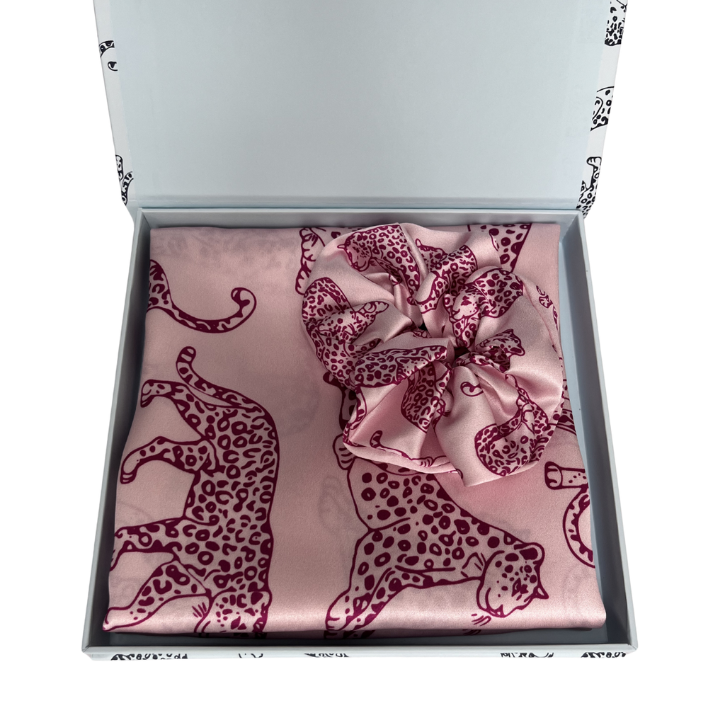 MYRN Silk pink leopard print silk pillowcase folded, with a matching pink scrunchie, inside a presentation box on a white background.