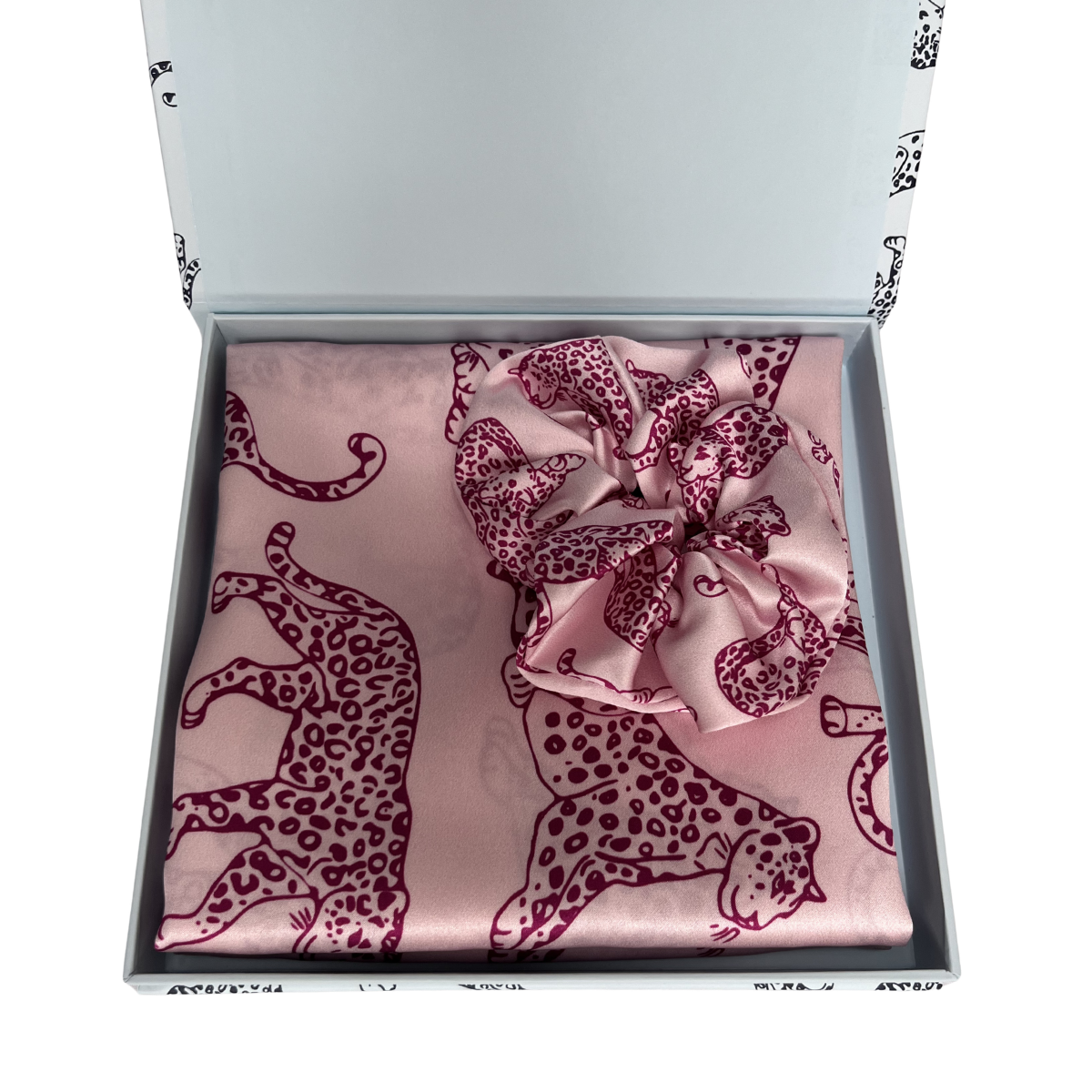 MYRN Silk pink leopard print silk pillowcase folded, with a matching pink scrunchie, inside a presentation box on a white background.