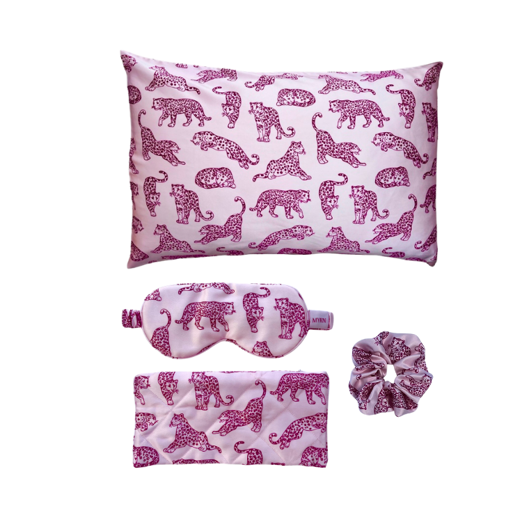MYRN Silk pink leopard print silk pillowcase on a white background with a matching large silk scrunchie and silk eye mask, with travel case.