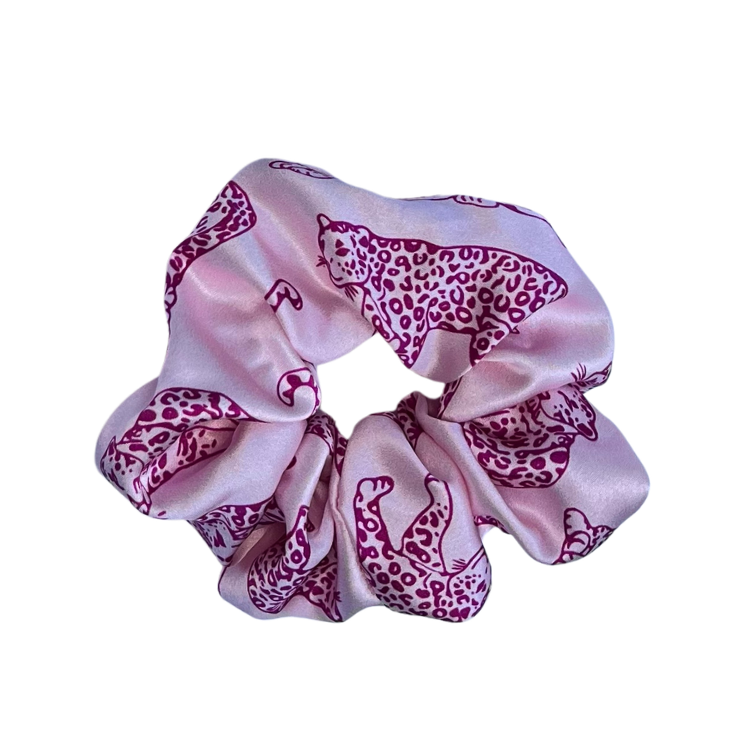 Pink leopard printed silk scrunchie on a white background